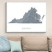 Map of Virginia on a wall above a beige sofa with blue and light green pillows.