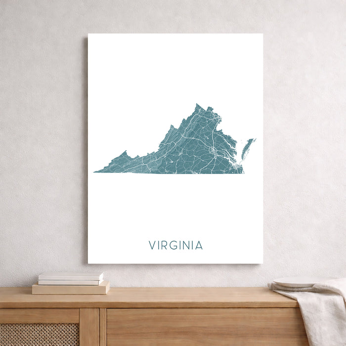 Framed map of Virginia on a wall above a wooden shelf.