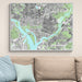 Framed map of Washington DC on a wall above a beige sofa with light blue pillows.