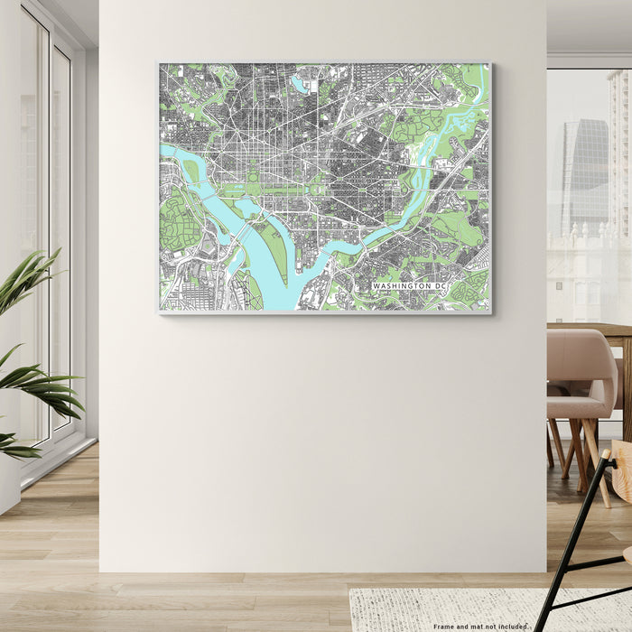 Framed map of Washington DC on a wall in a room with a plant and chair.