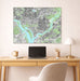Framed map of Washington DC above a desk with a laptop and lamp.