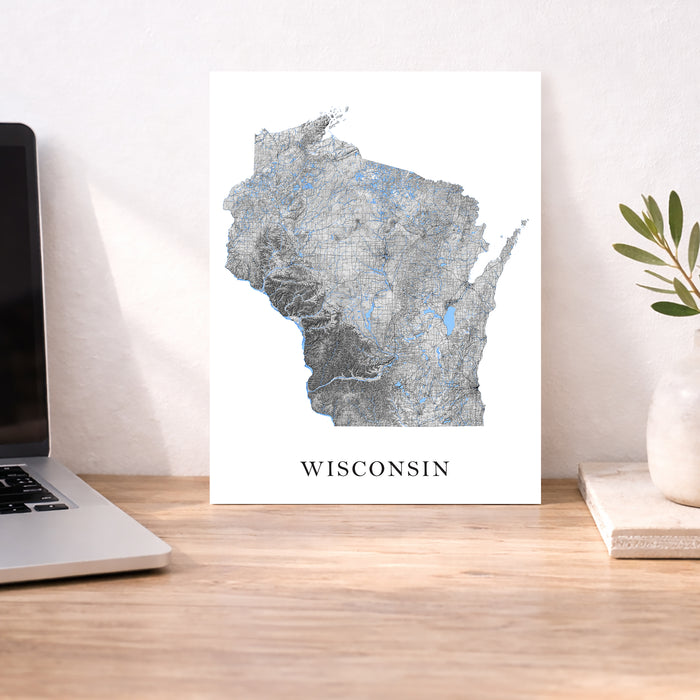 Map of Wisconsin on a desk with a laptop and plant