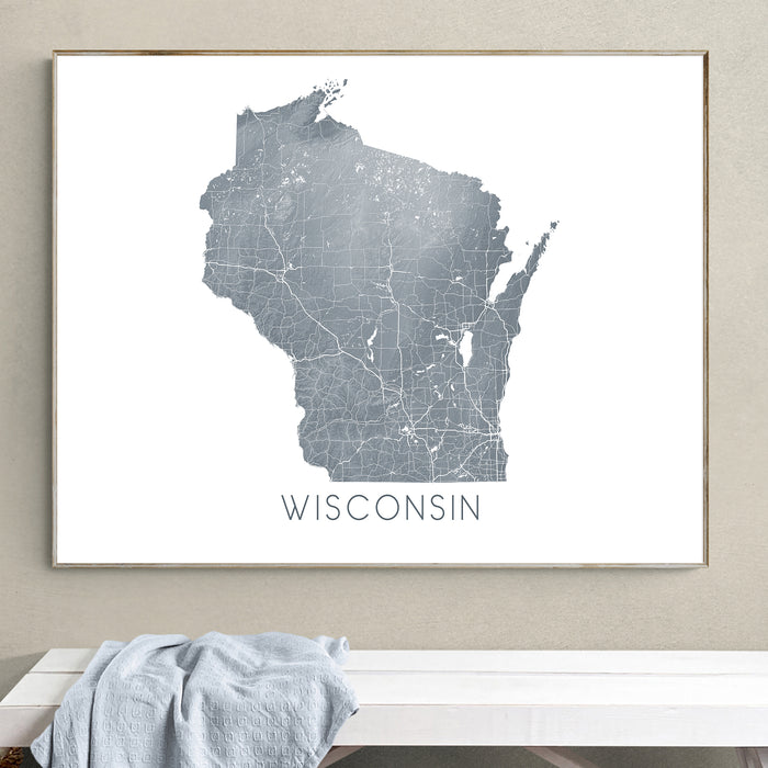Framed map of Wisconsin on a wall above a white bench.