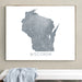 Framed map of Wisconsin on a wall above a white bench.