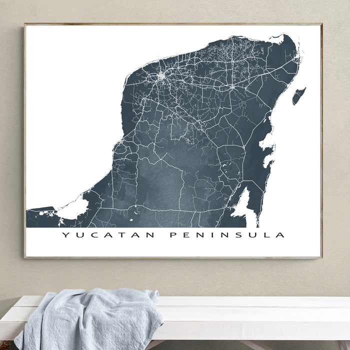 Framed map of Yucatan Peninsula on a wall above a white surface.