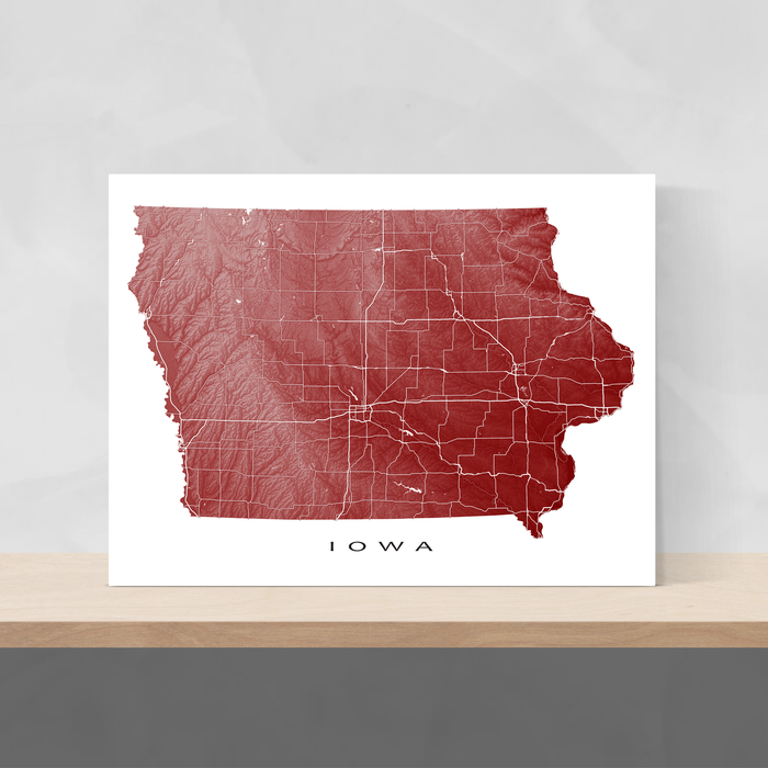 Iowa state map print with natural landscape and main roads in Merlot designed by Maps As Art.