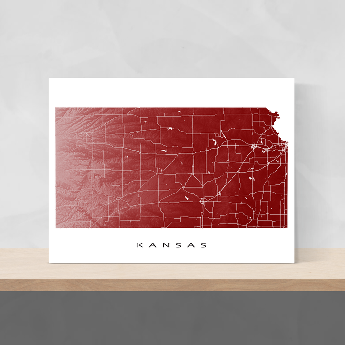 Kansas state map print with natural landscape and main roads in Merlot designed by Maps As Art.