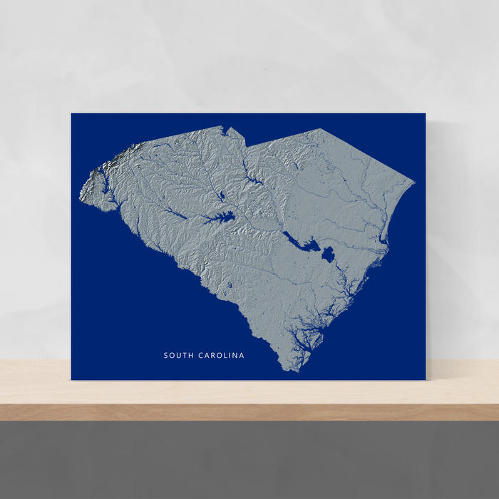 South Carolina state map print with natural landscape in greyscale and a navy blue background designed by Maps As Art.