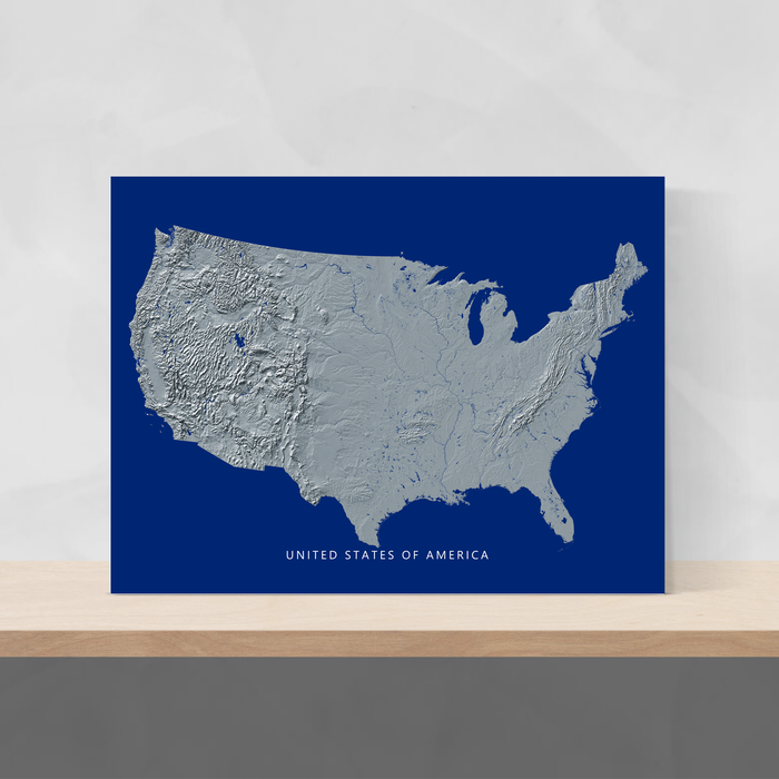 USA map print with natural landscape in greyscale and a navy blue background designed by Maps As Art.